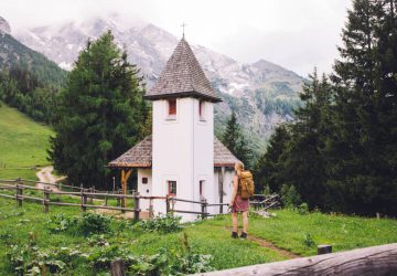Pilgrimage routes in Germany - Hiker with backpack in front of a small chapel on a hiking trail.