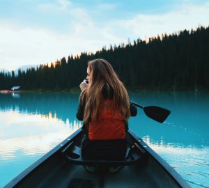 Paddeln im Kanadier - so klappt's 4 Basiswissen Paddeln im Kanadier - Frau in einem Boot auf einem See.