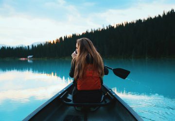 Basic knowledge: Paddling the Canadian Canoe 6 Basic paddling skills in Canada - woman in a boat on a lake.