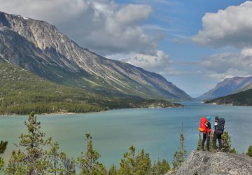 Five days on the Chilkoot Trail 6 Two trekkers with trekking backpacks look from a plateau onto the Yukon River.