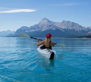 Basiswissen Paddeln 9 Paddling made easy - woman canoeing on a lake with a mountain in the background.
