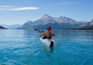 Basiswissen Paddeln 4 Paddling made easy - woman canoeing on a lake with a mountain in the background.