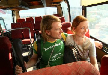 Backpacking insights - tips for a coach trip. A young couple is sitting on a bus.