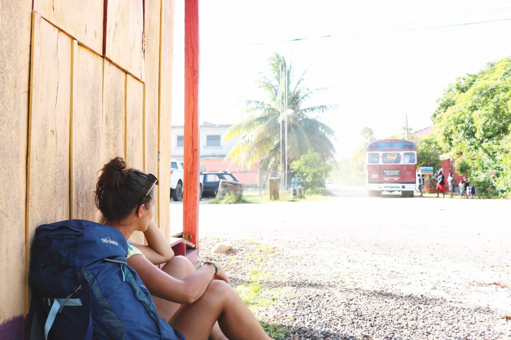 Ania sitzt neben ihrem Rucksack auf dem Boden und genießt das stressfreie Leben in Belize.