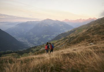 Europäische Fernwanderwege 2 Europäische Fernwanderwege stellen die abwechslungsreiche Landschaft Europas unter Beweis. Hier sind zwei Personen in einer grasigen Hügellandschaft unterwegs.