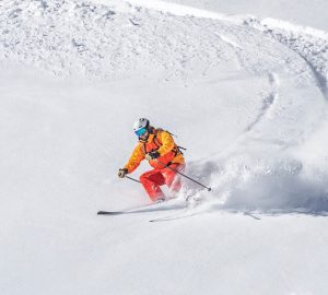 Lawinensicherheit Praxistipps. Im Bild: Ein Skifahrer fährt in Schlangenlinien den Berg hinunter.